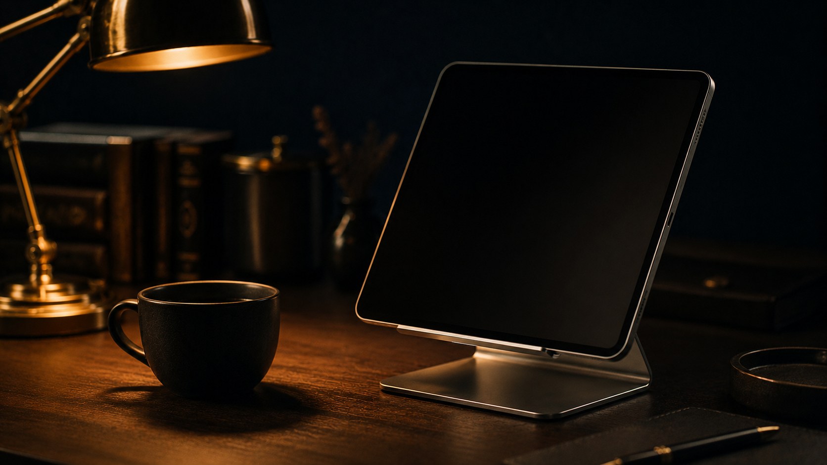 夜のデスクでスタンドに立てられたタブレットとコーヒーカップ